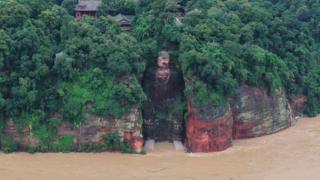 Buda gigante tallado en roca con agua de inundación alrededor de su base (18 de agosto)