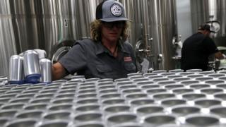 Kathryn Fisher con Can Van, una empresa de enlatado móvil, coloca latas de aluminio vacías en una cinta transportadora para llenarlas con cerveza en Devil's Canyon Brewery el 6 de junio de 2018 i