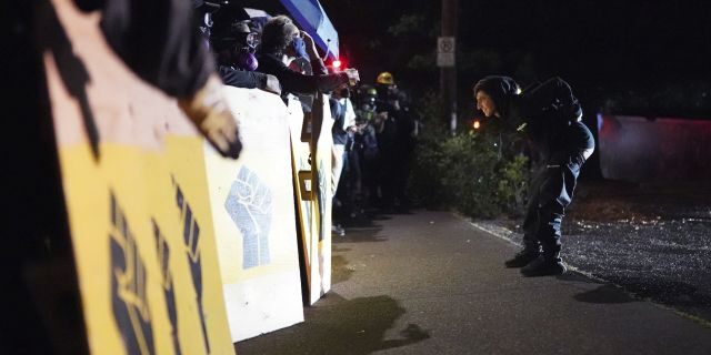 Un manifestante se burla de la policía de Portland mientras custodia la Oficina del Sheriff del Condado de Multnomah el viernes 7 de agosto de 2020 en Portland, Oregon (AP Photo / Nathan Howard)